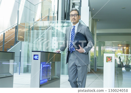 一位西裝革履的商人正從辦公室入口走過。圖片由Sky Perfect Tokyo Media Center提供。 130024058