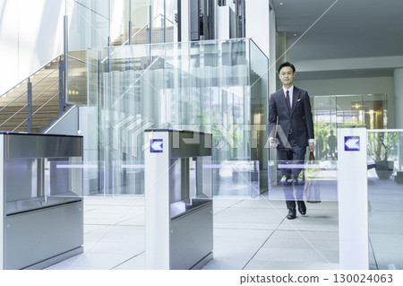 一位西裝革履的商人正從辦公室入口走過。圖片由Sky Perfect Tokyo Media Center提供。 一位西裝革履的商人正從辦公室入口走過。圖片由Sky Perfect Tokyo Media Center提供。 130024063