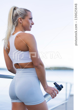 Fitness enthusiast enjoying outdoor workout with hydration and mindfulness 130025648