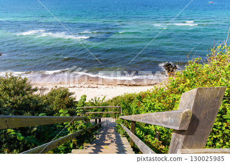 Wooden stairs leads down to a sandy sea beach with azure water Wooden stairs leads down to a sandy sea beach with azure water 130025985