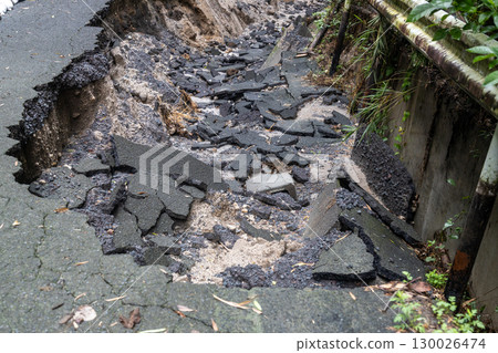 Heavy rain has caused the asphalt road to collapse. 130026474