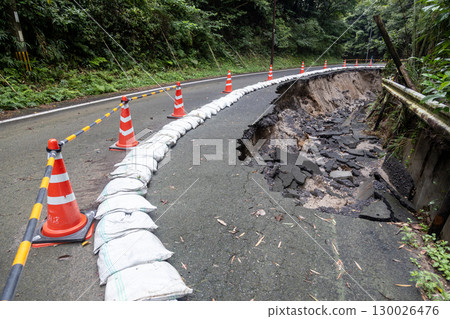 Heavy rain has caused the asphalt road to collapse. 130026476