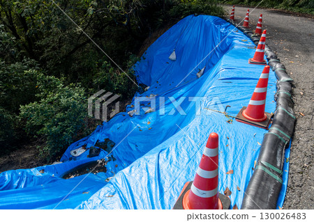A road that collapsed due to heavy rain and is being protected with blue tarps A road that collapsed due to heavy rain and is being protected with blue tarps 130026483