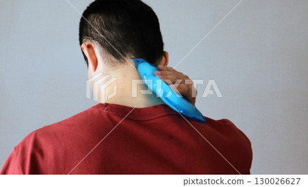 Back view of a person cooling his body with an ice pack Back view of a person cooling his body with an ice pack 130026627