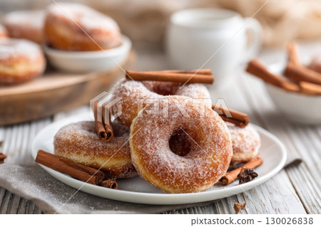 Delicious donuts pile against blue wood rustic wall. Donut stack on a plate. Candy shop showcase. Doughnut heap with sugar powder. Pastry, sweets. Homemade deep fried dessert. Bakery, confectionery. 130026838