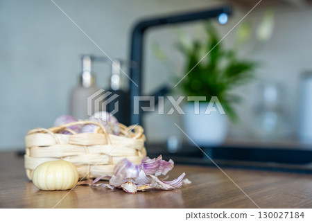 Basket with Chinese single clove garlic and one peeled garlic clove on kitchen countertop. Cooking preparation, fresh ingredient, and natural seasoning. Basket with Chinese single clove garlic and one peeled garlic clove on kitchen countertop. Cooking preparation, fresh ingredient, and natural seasoning. 130027184