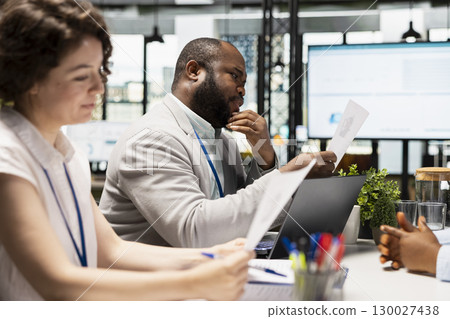 Diverse HR interviewers meeting with an applicant to review CV document, focusing on talent acquisition, work experience and qualifications for employment and onboarding process in enterprise. Diverse HR interviewers meeting with an applicant to review CV document, focusing on talent acquisition, work experience and qualifications for employment and onboarding process in enterprise. 130027438
