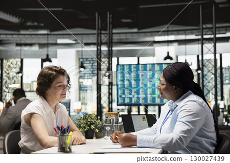 Hiring manager conducting a detailed job interview with applicant, reviewing the candidate qualifications, CV resume and potential onboarding for career advancement within the company. Hiring manager conducting a detailed job interview with applicant, reviewing the candidate qualifications, CV resume and potential onboarding for career advancement within the company. 130027439