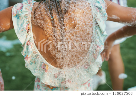 Child Enjoying Bubble Play Outdoors in Summer 130027503