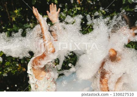 Joyful Girls Playing with Bubbles in Summer Sunshine 130027510