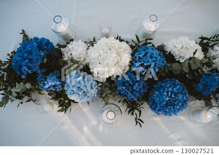Elegant Floral Arrangement with Candles on Table 130027521