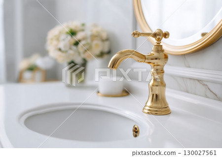 Modern golden faucet and marble stone sink. Stylish white sink, faucets in a light interior. Copper brass tap. Domestic Appliances. Clean bright bathroom. Household equipment. New Contemporary style Modern golden faucet and marble stone sink. Stylish white sink, faucets in a light interior. Copper brass tap. Domestic Appliances. Clean bright bathroom. Household equipment. New Contemporary style 130027561