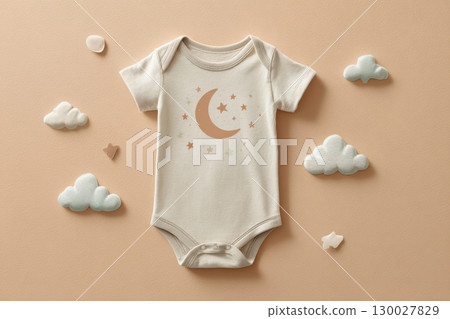 Baby white onesie on a creamy beige background. Fashion newborn clothes. Flat lay, top view. Kids soft clothing, soft moon, stars, clouds. Infant trendy bodysuit made of organic eco friendly cotton. 130027829