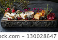 variety of cheeses served on wooden board. assorted cheese, garnished with herbs and berries 130028647