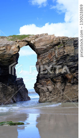 Spectacular natural rock arch formation on the beach of Playa de las Catedrales in Galicia, Spain. 130028869