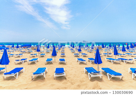 Levante sandy beach with chaise lounges and umbrellas, Playa Platja De Llevant in Benidorm city centre on Costa Blanca coast Mediterranean Sea, Isla de Benidorm Island on horizon in summer day, Spain Levante sandy beach with chaise lounges and umbrellas, Playa Platja De Llevant in Benidorm city centre on Costa Blanca coast Mediterranean Sea, Isla de Benidorm Island on horizon in summer day, Spain 130030690