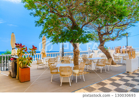 Street restaurant outdoor cafe on Mediterranean Balcony El Castell Old town Benidorm city historic centre with view Mediterranean Sea azure water in summer day, Valencian Community, Spain 130030693