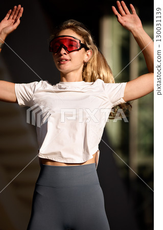 Woman exercising outdoors wearing stylish activewear and sunglasses on a sunny day Woman exercising outdoors wearing stylish activewear and sunglasses on a sunny day 130031139