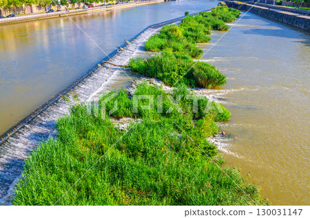 Small waterfall with green grass in Main river water schleuse lock in canal 130031147