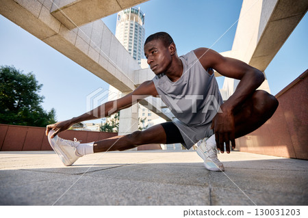 Athlete stretching in a modern architectural urban environment Athlete stretching in a modern architectural urban environment 130031203