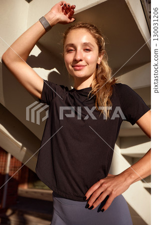 Smiling cheerful woman posing in casual attire in an urban outdoor setting 130031206