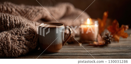 Cozy Autumn Scene with Candle and Mug on Wooden Table 130031286