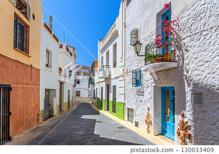 Old town Calpe city historic centre narrow street with typical houses colorful traditional buildings in sunny summer day, Calp Casco Antiguo, province of Alicante, Valencian Community, Spain Old town Calpe city historic centre narrow street with typical houses colorful traditional buildings in sunny summer day, Calp Casco Antiguo, province of Alicante, Valencian Community, Spain 130033409