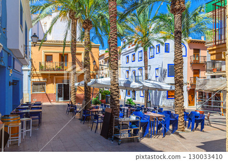 Old town Calpe city historic centre with street restaurant outdoor cafe on small square Plaza Espana, typical houses colorful traditional buildings, province of Alicante, Valencian Community, Spain Old town Calpe city historic centre with street restaurant outdoor cafe on small square Plaza Espana, typical houses colorful traditional buildings, province of Alicante, Valencian Community, Spain 130033410