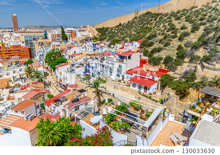 Aerial view of Alicante old town Barrio de Santa Cruz neighborhood narrow street, typical white houses, traditional colorful buildings in Alicante city historical centre, Valencian Community, Spain 130033630