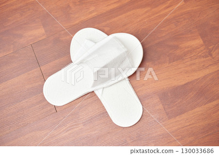 White indoor slippers on wooden floor background with cozy minimalist style White indoor slippers on wooden floor background with cozy minimalist style 130033686