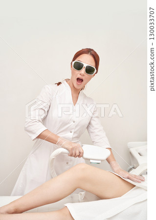 Female asian adult wearing protective eyewear performing laser hair removal Female asian adult wearing protective eyewear performing laser hair removal 130033707