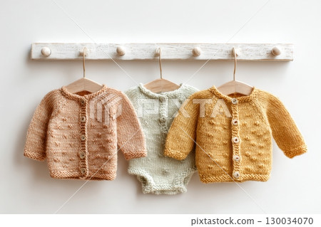 Set of baby cardigan, sweaters, onesies on a light background. Fashion newborn clothes made with organic cotton, wool. Cute knitted kids soft clothing. Infant trendy bodysuit natural warm earthy color Set of baby cardigan, sweaters, onesies on a light background. Fashion newborn clothes made with organic cotton, wool. Cute knitted kids soft clothing. Infant trendy bodysuit natural warm earthy color 130034070