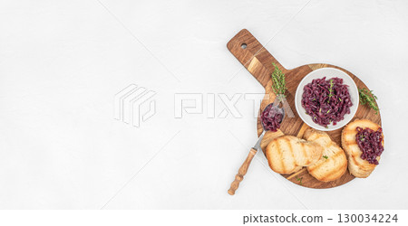 Toasted bread with caramelized red onion spread served on a wooden board. Long banner format. top view. copy space Toasted bread with caramelized red onion spread served on a wooden board. Long banner format. top view. copy space 130034224