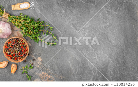 Fresh herbs garlic pepper and sea salt on dark stone background. top view. copy space 130034256