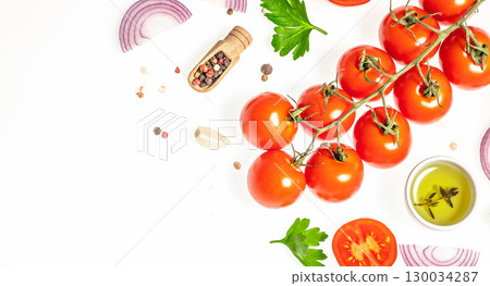 Fresh tomatoes on vine with onion garlic herbs and olive oil on white background. top view. copy space Fresh tomatoes on vine with onion garlic herbs and olive oil on white background. top view. copy space 130034287