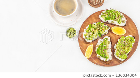 Avocado toast with seeds and coffee on white background, healthy breakfast concept, Long banner format. top view. copy space Avocado toast with seeds and coffee on white background, healthy breakfast concept, Long banner format. top view. copy space 130034304