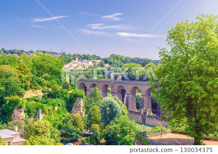 Pulvermuhl Viaduct Biisser Breck railway stone arch viaduct bridge across Alzette valley and Maierchen stone wall in Luxembourg City historical centre, park with green trees and blue sky background Pulvermuhl Viaduct Biisser Breck railway stone arch viaduct bridge across Alzette valley and Maierchen stone wall in Luxembourg City historical centre, park with green trees and blue sky background 130034375