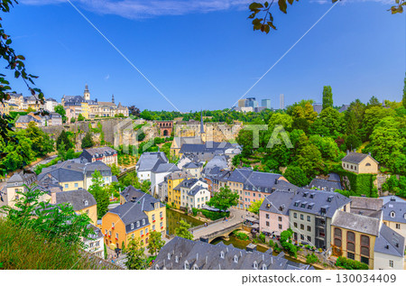 Luxembourg City historical centre aerial panoramic view, old colorful buildings and green trees, Luxembourg cityscape skyline blue sky, panorama of Luxembourg old town Grund and Ville Haute districts 130034409