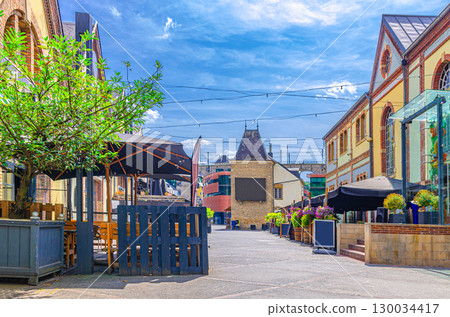 Les Rives de Clausen restaurant and bar district in Grund quarter of Luxembourg City historical centre with old buildings, street restaurants and cafes, blue sky background 130034417