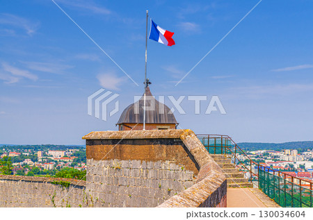 National Flag of France on Guard tower stone wall rampart in Citadel of Citadelle de medieval fortress in old town Besancon city historic centre in sunny summer day, France 130034604