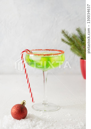 Xmas Green Punch in glass decorated sugar rim on white table make of cool lime sherbet. Tasty beverage for Christmas holiday. Vertical. 130034637