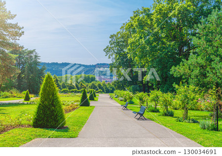 Parc des Glacis park with green trees and bushes, grass lawn and benches on path Parc des Glacis park with green trees and bushes, grass lawn and benches on path 130034691