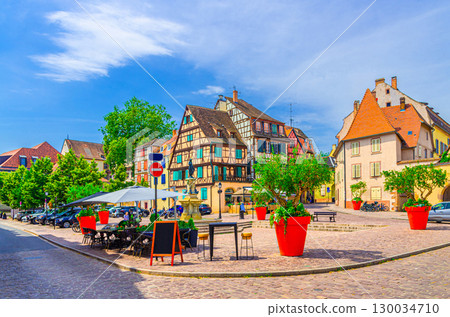 Old houses half-timbered style colorful facade medieval buildings multicolored walls and street restaurants on small square in old town Colmar city historic centre, Alsace Grand Est region, France Old houses half-timbered style colorful facade medieval buildings multicolored walls and street restaurants on small square in old town Colmar city historic centre, Alsace Grand Est region, France 130034710