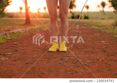 Fit sportswoman jump rope outdoors in autumn park Fit sportswoman jump rope outdoors in autumn park 130034741