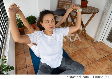 Mother and Child Practicing Yoga on a Relaxing Balcony 130034955
