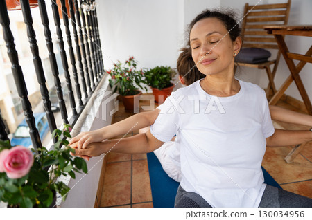 Mother and Child Practicing Relaxation Exercises on a Sunlit Balcony 130034956