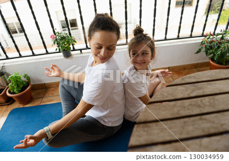 Mother and Daughter Practicing Yoga Together on a Balcony Mother and Daughter Practicing Yoga Together on a Balcony 130034959