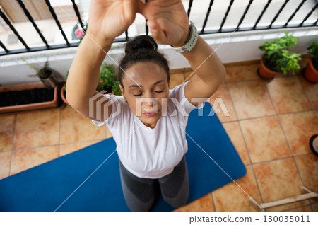 Woman Practicing Mindful Yoga Exercises on a Mat in an Outdoor Setting 130035011