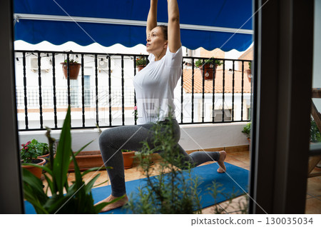 Woman Practicing Yoga on Balcony in Natural Light Woman Practicing Yoga on Balcony in Natural Light 130035034