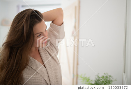 Portait of beautiful woman standing in bathroom in bathrobe. Portait of beautiful woman standing in bathroom in bathrobe. 130035572